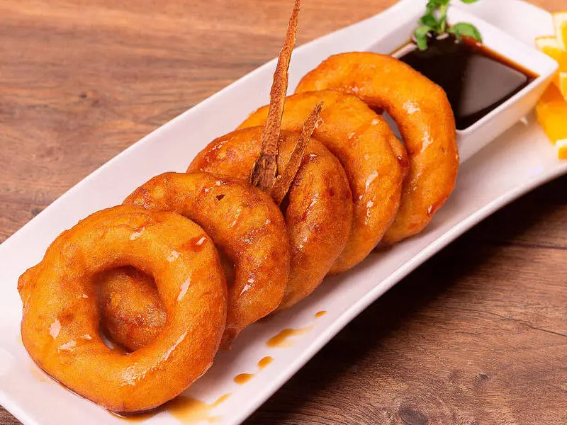 Picarones tradicionais de Lima servidos com calda de mel de cana