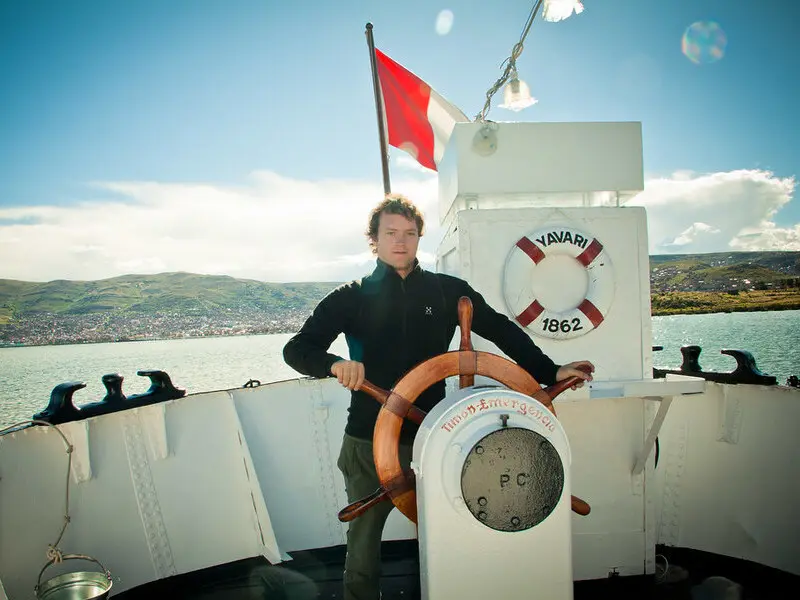 Turista vestindo roupas em camadas para enfrentar as mudanças de clima em Puno.