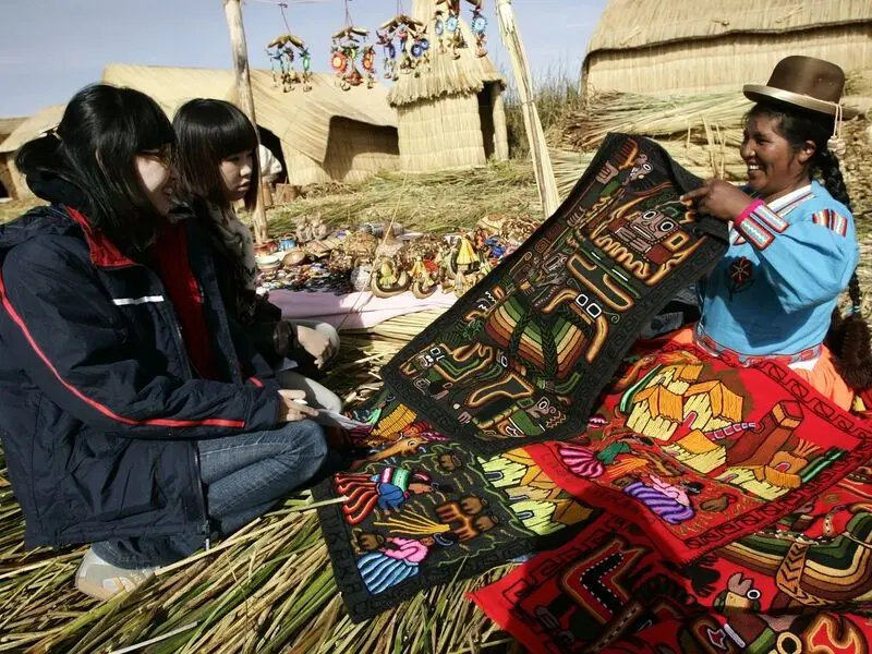 Comprador segurando moedas e notas para pagar em mercados locais de Puno.