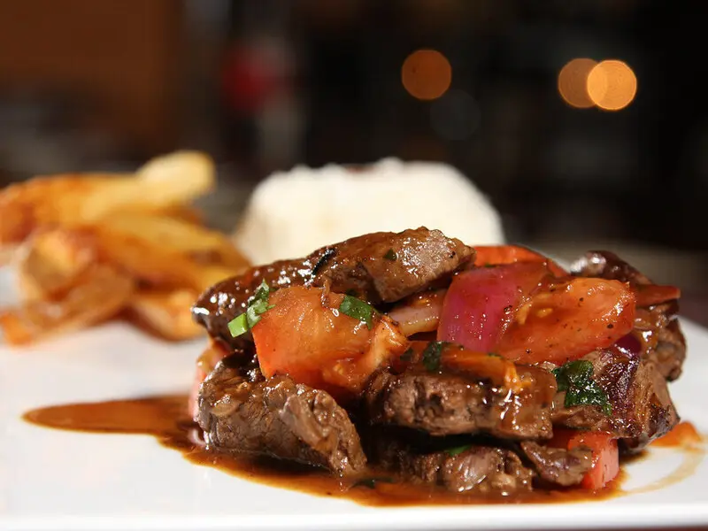 Lomo saltado peruano servido com arroz e batatas